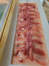 Light pink soap with darker pink swirls in the mold.