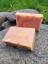 Orange, yellow and pink soap with a tiny bit of white with swirls.