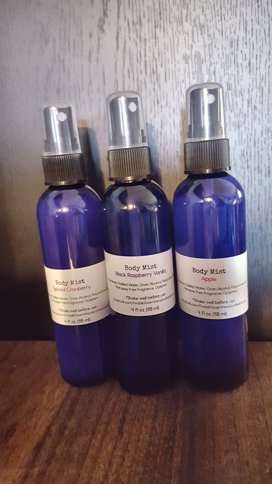 Three body mists in a 4 oz blue bottle with spray top.  Pictured are Cranberry, Black Raspberry Vanilla and Apple.