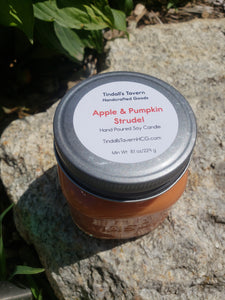 Apple & Pumpkin Strudel Soy candle that is orange in color in an 8 oz Mason jar with a pewter lid.