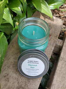 Patchouli Rain Soy candle that is greenish in color in an 8 oz Mason jar, the lid is off to show the top of the candle and the pewter lid is sitting next to it.