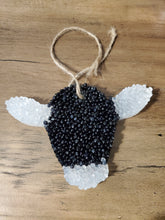 Black and white cow head hanging air freshener.