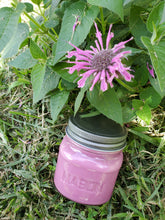 Pink Soy candle that has a pink flower in the picture above it.  The candle is in an 8 oz Mason jar with a pewter lid.