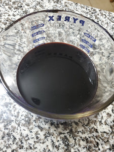 Picture of the Elderberry Juice after it was strained and before adding sweetener.  Dark purple color.