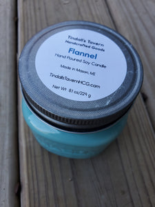 Flannel soy candle that is light blue in color in an 8 oz Mason jar witha  pewter lid.