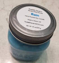 Rain Soy candle that is blue in color in an 8 oz Mason jar with a pewter lid.