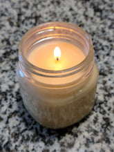 White Soy candle that is lit.