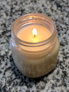 White Soy candle that is lit.