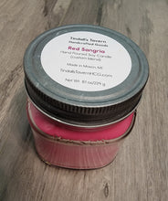 Red Sangria Soy candle that is reddish in color in an 8 oz Mason jar with a pewter lid.