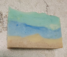Beach Bum soap bar, bottom two layers look like sand and has some apricot shells in it, there is a blue layer for the water and a teal layer with a bit of white for the sky or more water.  Soap bar minimum weight is 3.8 oz.