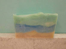 Beach Bum soap bar.  Bottom two layers resemble sand with some apricot shells, there is a blue layer to resemble water and a teal layer with some white to resemble more water or the sky.