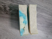 Top of the soap bars, one is all tan with speckles, the other has some tan with speckles and blue and white. 