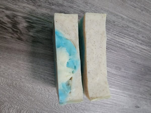 Top of the soap bars, one is all tan with speckles, the other has some tan with speckles and blue and white. 
